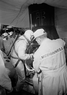 Astronaut John Young assisted into Gemini spacecraft in white room